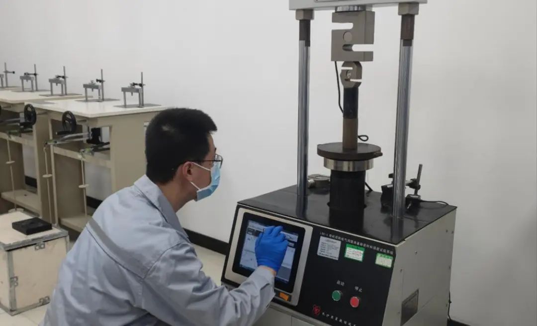 佛山市交通科技有限公司实验室内，科研人员对试块进行强度测试